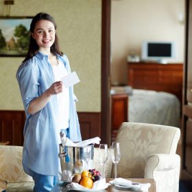 Young female standing in dining-room in hotel